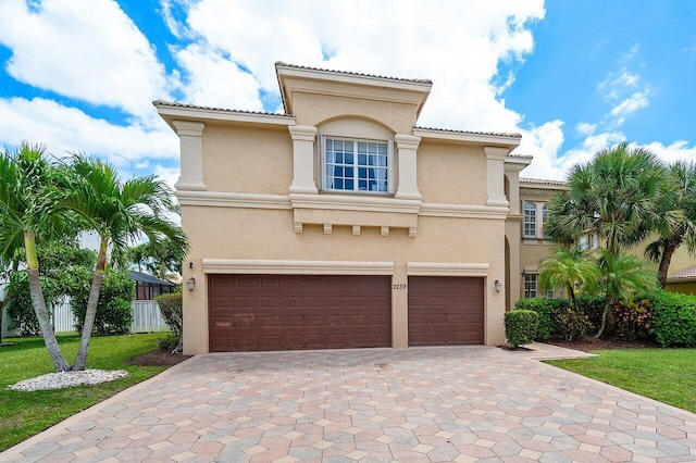 mediterranean / spanish-style house featuring a front yard and a garage