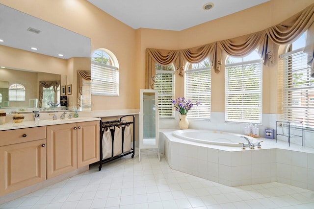 bathroom featuring tiled tub and vanity