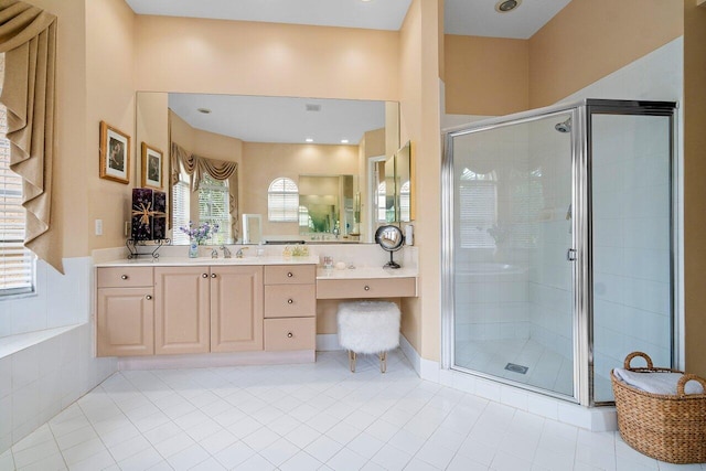 bathroom with walk in shower, vanity, and tile patterned flooring