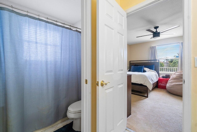 bathroom with ceiling fan, a textured ceiling, toilet, and tile patterned floors