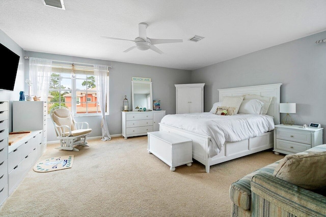 carpeted bedroom with ceiling fan and a textured ceiling