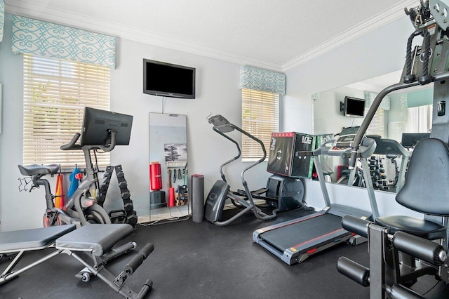 exercise room with ornamental molding and a textured ceiling