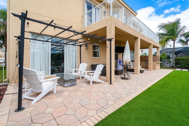 view of patio featuring a balcony and exterior kitchen