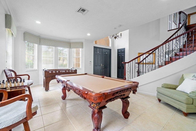 rec room with light tile patterned flooring, a textured ceiling, a chandelier, billiards, and crown molding