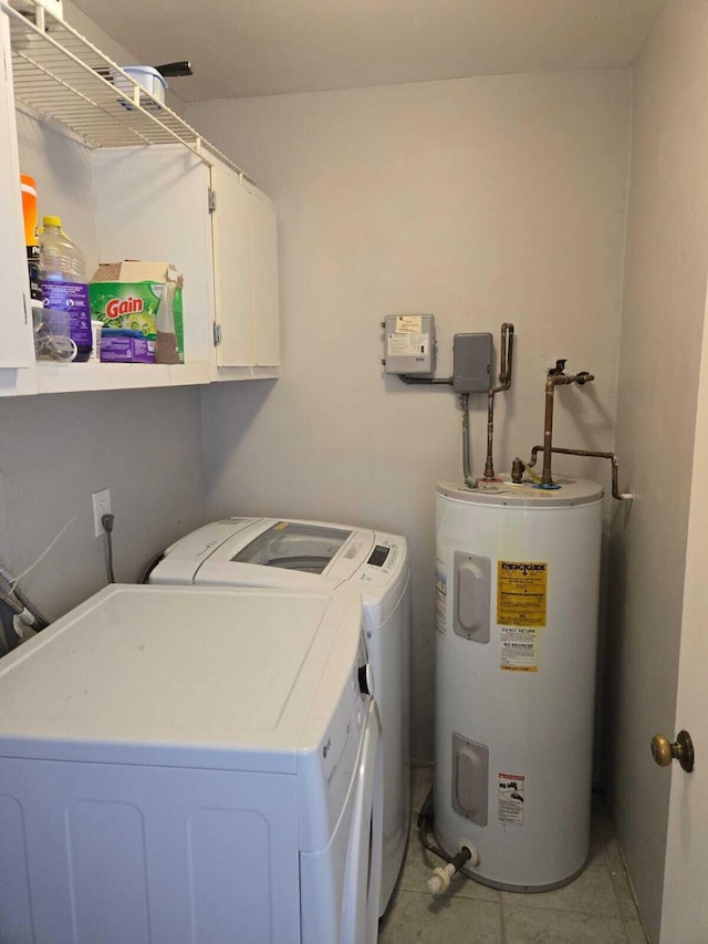 laundry room with electric water heater, washing machine and clothes dryer, and cabinets