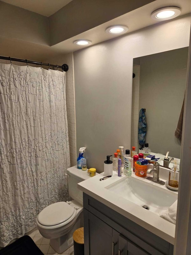 bathroom featuring walk in shower, vanity, toilet, and tile patterned flooring