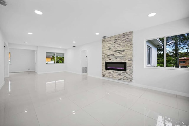 unfurnished living room featuring tile patterned floors and a large fireplace