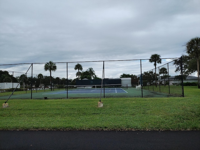 view of tennis court featuring a yard