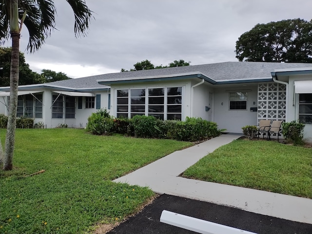 single story home featuring a front lawn