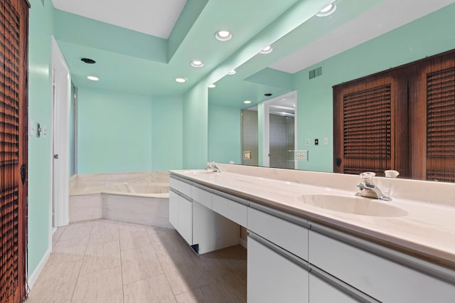 bathroom with vanity, tiled tub, and tile patterned floors