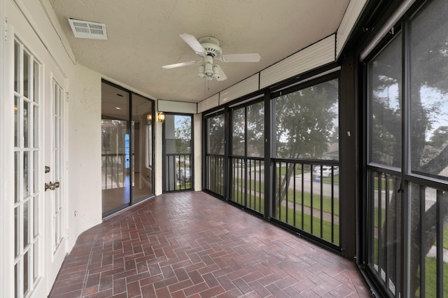 unfurnished sunroom featuring ceiling fan