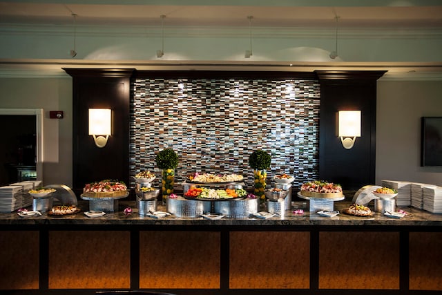 bar featuring dark stone counters and ornamental molding