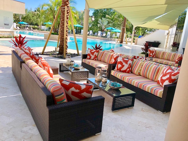 view of patio featuring a community pool and an outdoor living space