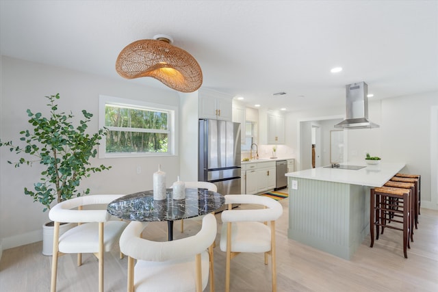 dining room featuring sink and light wood-type flooring