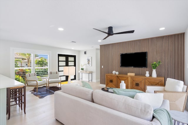 living room with ceiling fan and light hardwood / wood-style floors