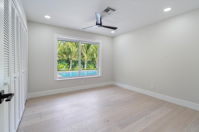 interior space featuring a closet, ceiling fan, light hardwood / wood-style floors, and a textured ceiling