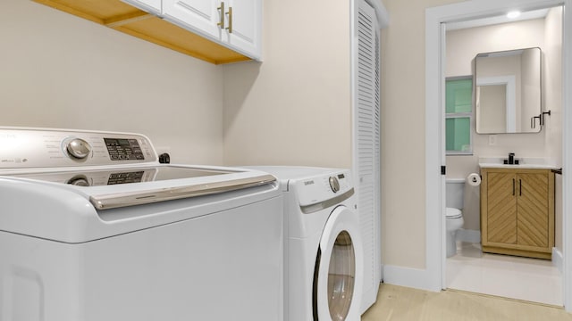 laundry room featuring cabinets and washing machine and clothes dryer