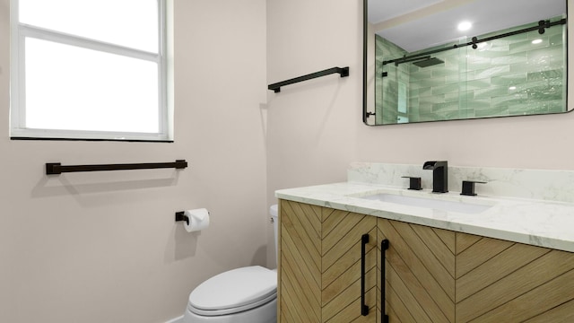 bathroom with vanity, a shower with shower door, and toilet