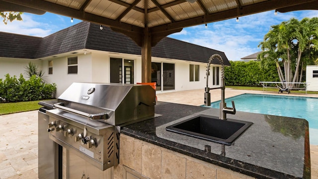 view of patio / terrace with sink, a gazebo, area for grilling, a grill, and a fenced in pool