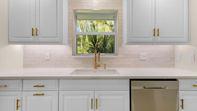 kitchen featuring dishwasher, sink, white cabinetry, tasteful backsplash, and light stone countertops