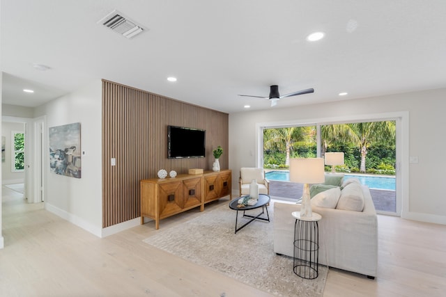 living room with ceiling fan and light wood-type flooring