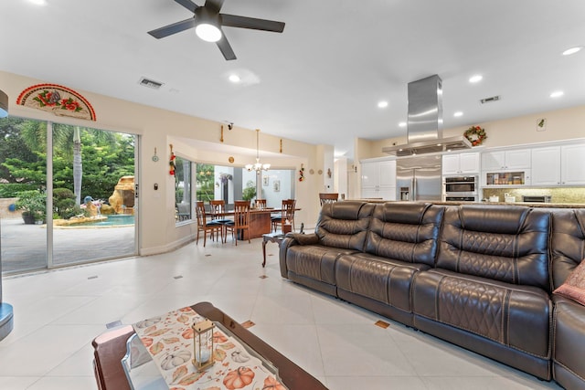 living room featuring ceiling fan with notable chandelier and light tile patterned floors