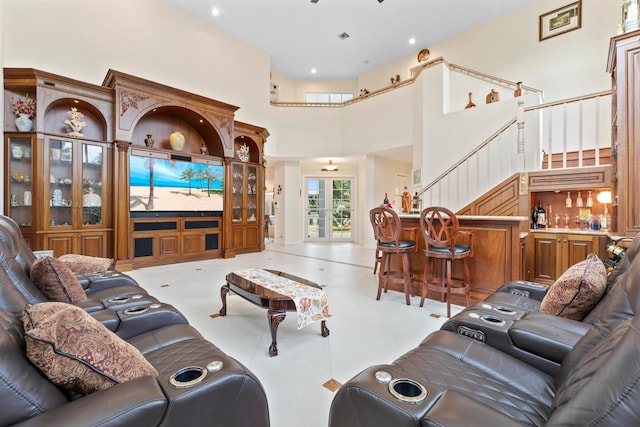 living room with bar area and a towering ceiling