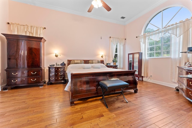 bedroom featuring ceiling fan, crown molding, and light hardwood / wood-style floors