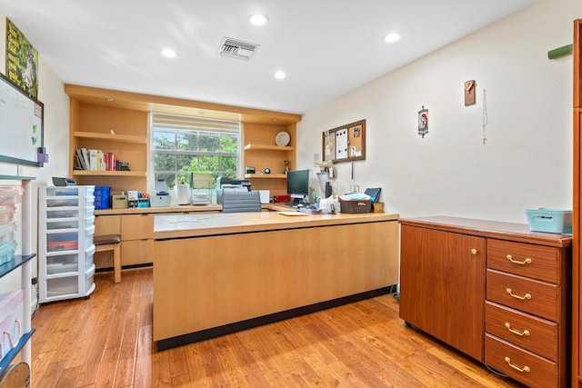 office space featuring built in desk and light hardwood / wood-style floors