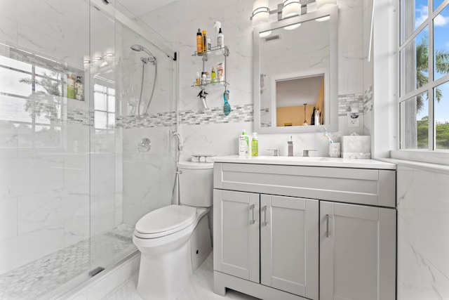 bathroom featuring tile walls, vanity, a shower with shower door, and toilet