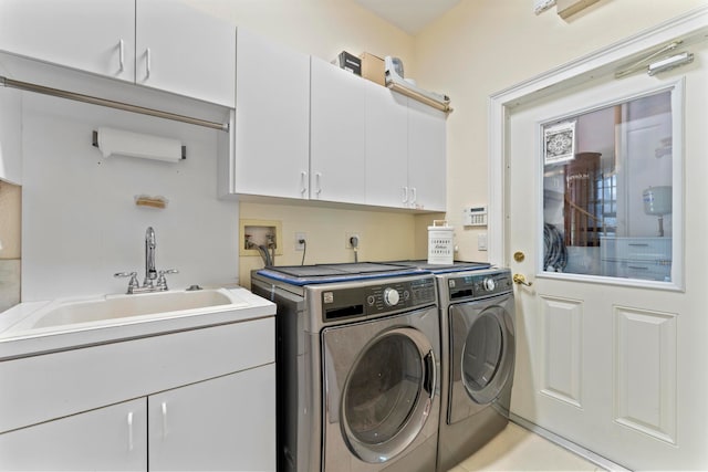 washroom featuring washer and dryer, cabinets, and sink