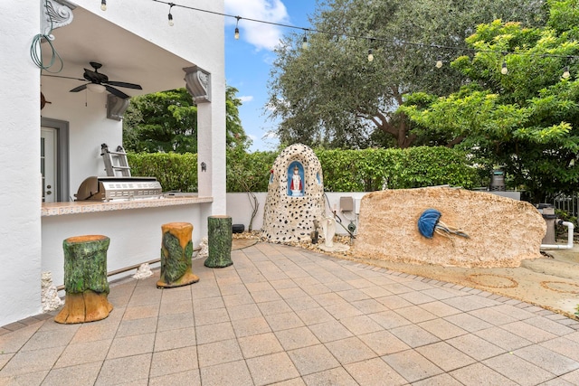 view of patio / terrace featuring ceiling fan and exterior kitchen