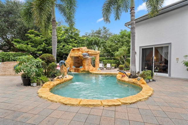 view of swimming pool featuring pool water feature and a patio