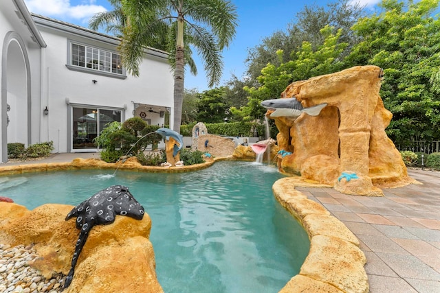 view of swimming pool featuring pool water feature and a patio area