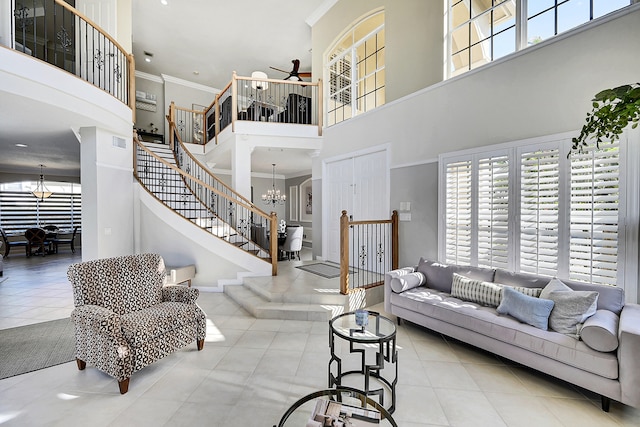 tiled living room featuring crown molding, a healthy amount of sunlight, and a high ceiling