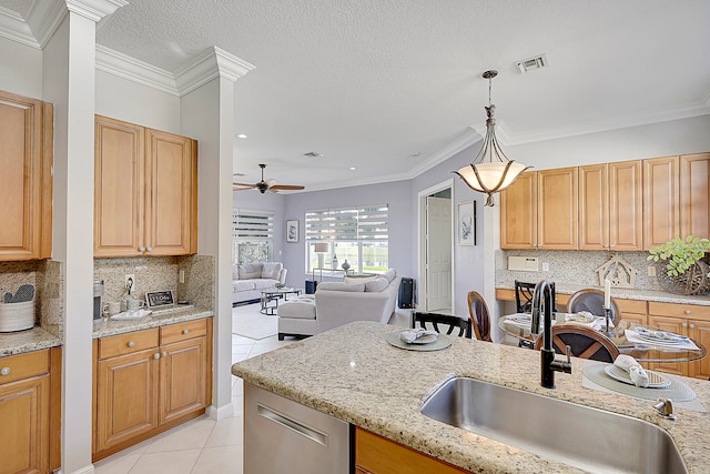 kitchen with sink, ornamental molding, light tile patterned floors, and hanging light fixtures