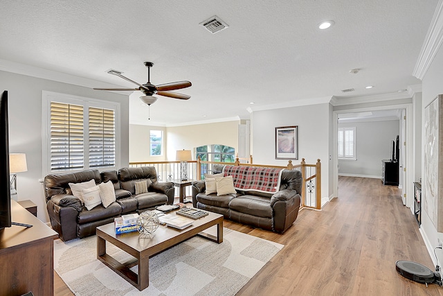 living room featuring light hardwood / wood-style flooring, a textured ceiling, and crown molding