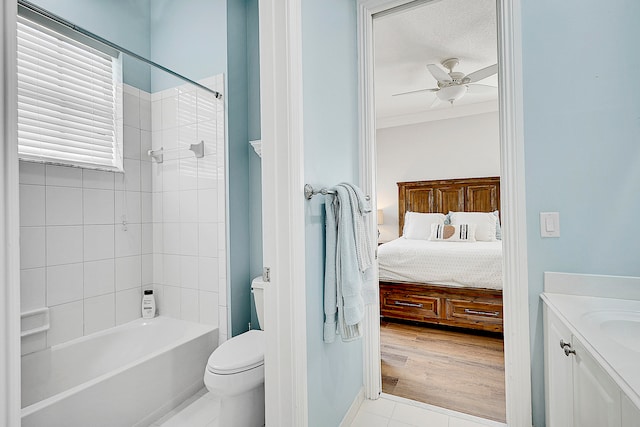 full bathroom featuring ceiling fan, hardwood / wood-style flooring, toilet, vanity, and tiled shower / bath combo