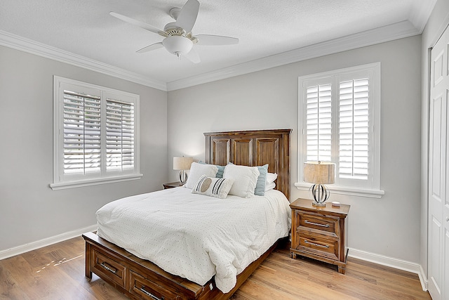 bedroom with a textured ceiling, multiple windows, light wood-type flooring, and ceiling fan