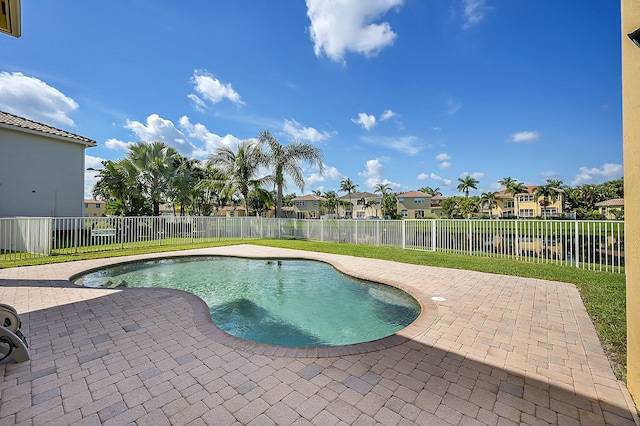 view of pool featuring a patio area, a lawn, and a water view