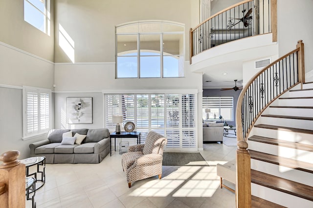 tiled living room featuring a wealth of natural light and a towering ceiling