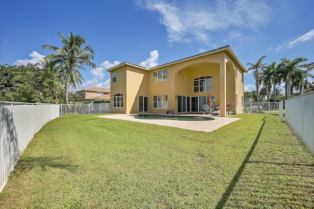 back of property with a yard and a patio area