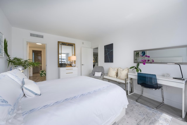 bedroom with built in desk and light hardwood / wood-style flooring