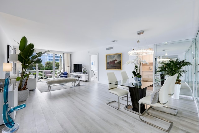 dining space featuring a notable chandelier, light wood-type flooring, and floor to ceiling windows