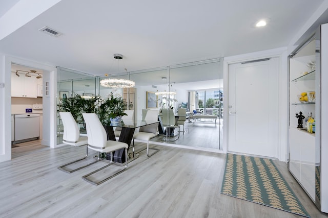 dining room with light hardwood / wood-style flooring and a chandelier