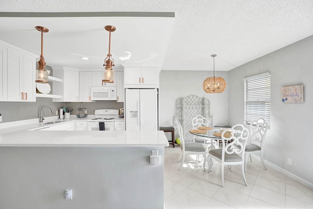 kitchen featuring white cabinets, decorative light fixtures, kitchen peninsula, and white appliances