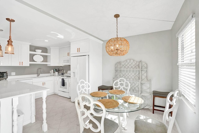 dining space with a notable chandelier and sink