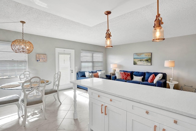 kitchen with pendant lighting, a textured ceiling, and white cabinetry