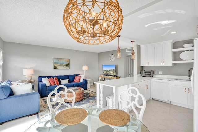 kitchen with white cabinets, white dishwasher, sink, kitchen peninsula, and a textured ceiling