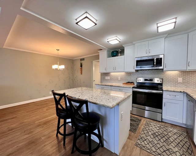 kitchen featuring stainless steel appliances, white cabinets, and a center island